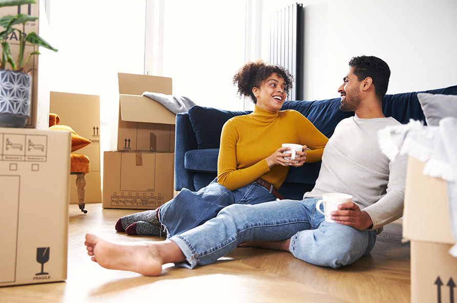 A happy couple surrounded by moving boxes in their new home