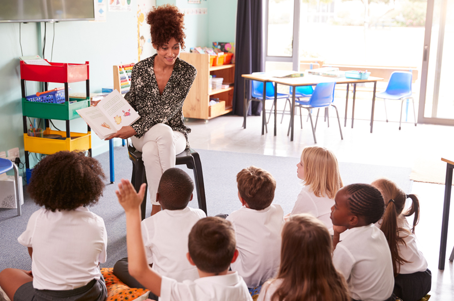 Teacher reading a book in classroom