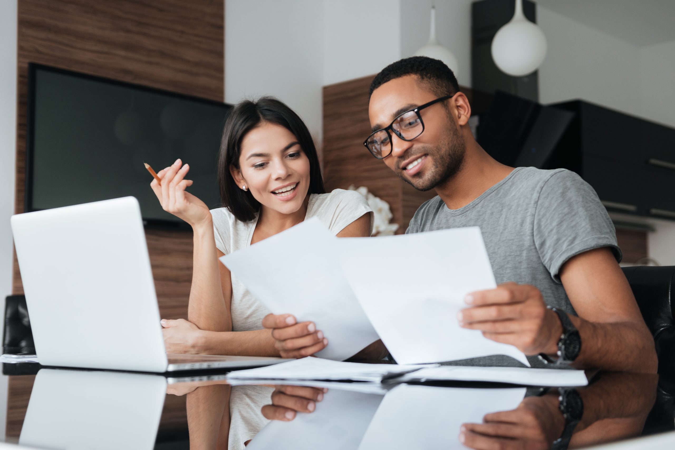 Couple looking at papers by computer